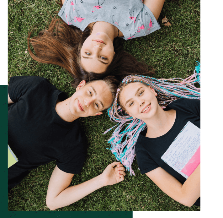 Teenagers group laying on grass photo - hero image - Fortivo